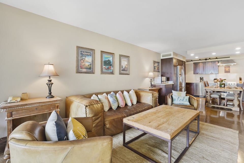 Unwind in a beautifully decorated living room featuring plush leather seating, island-inspired decor, and a warm, inviting atmosphere—perfect for relaxing after a day at the beach.
