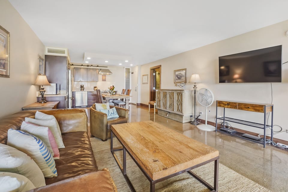 Kick back in this bright and airy living space with a large flat-screen TV, comfortable seating, and seamless access to the open kitchen and dining area.