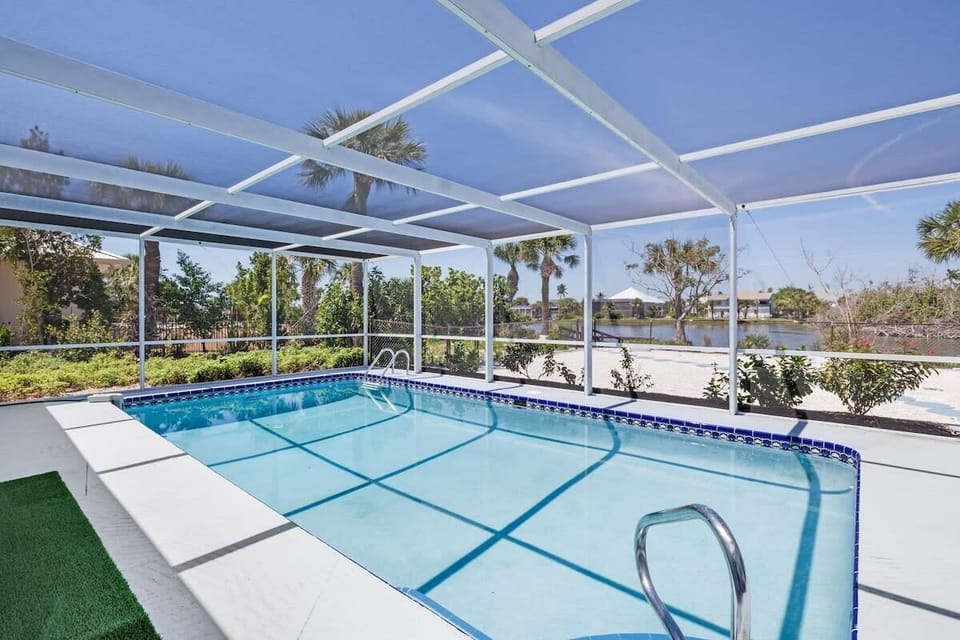 Caged and heated pool overlooking gorgeous lake with dock