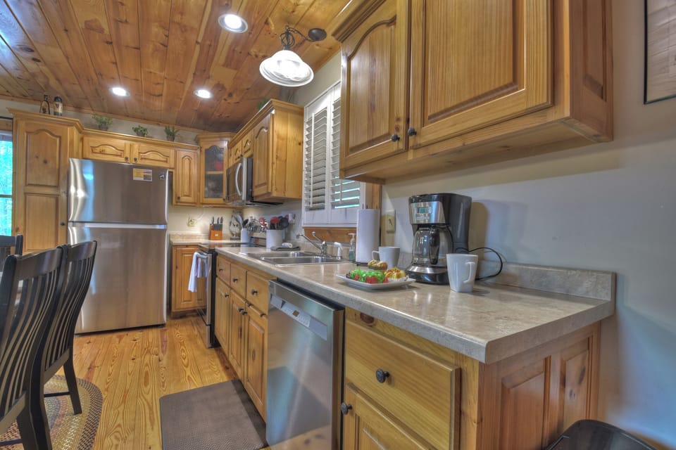 Fully stocked kitchen with stainless appliance at this cabin rental in the Coosawattee River Resort