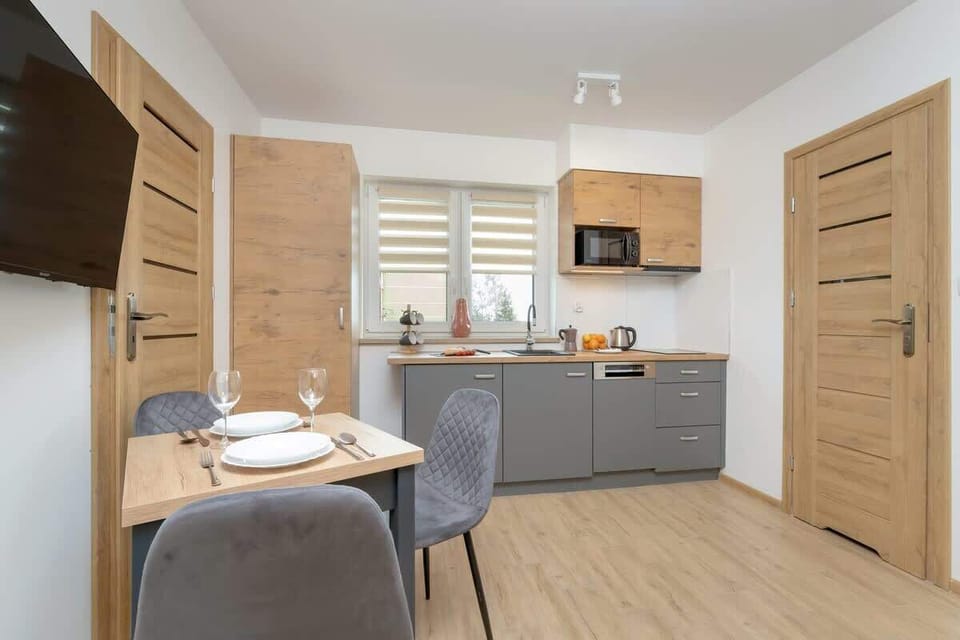 Dining table with tableware and kitchenette.