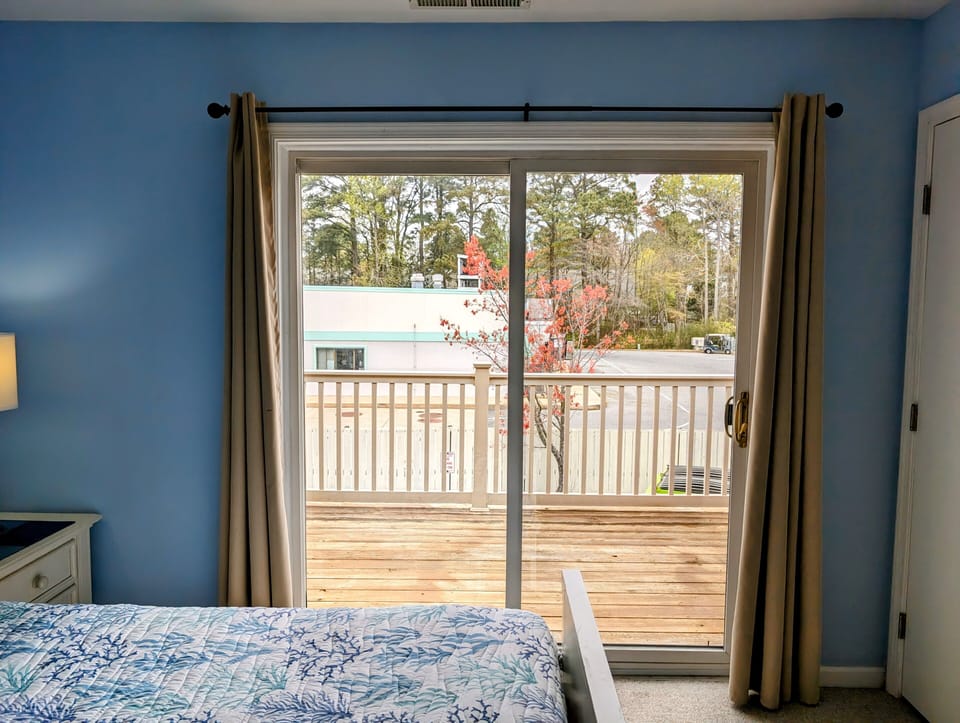 4 Lagoona Drive, Sea Pines, Bethany Beach-Balcony View - View from the bedroom looking through the sliding glass door toward the private wooden balcony.