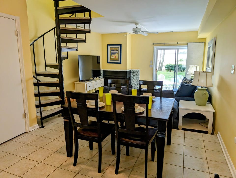 4 Lagoona Drive, Sea Pines, Bethany Beach - Dining - Dining area featuring a dark wood table and chairs next to a black spiral staircase.
