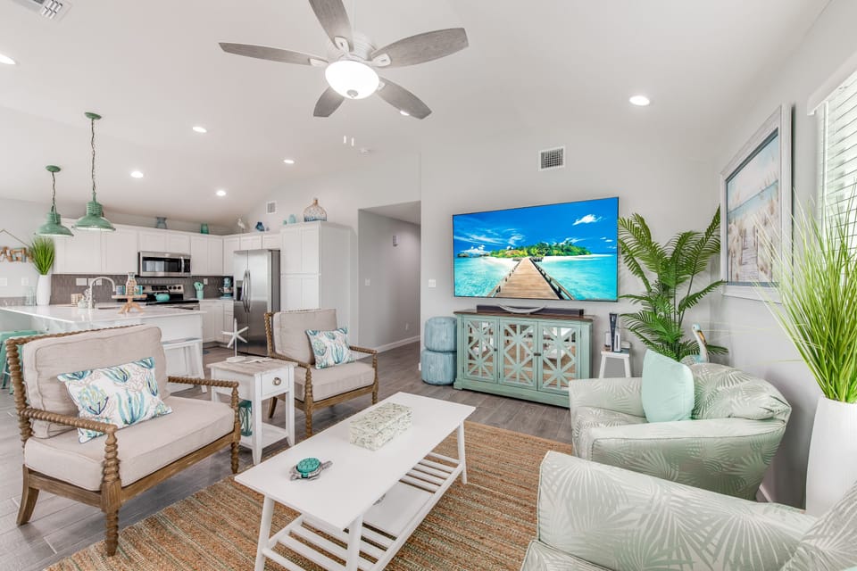 Unwind in your coastal-inspired living space with tropical decor, comfy seating, and an open kitchen perfect for vacation meals.