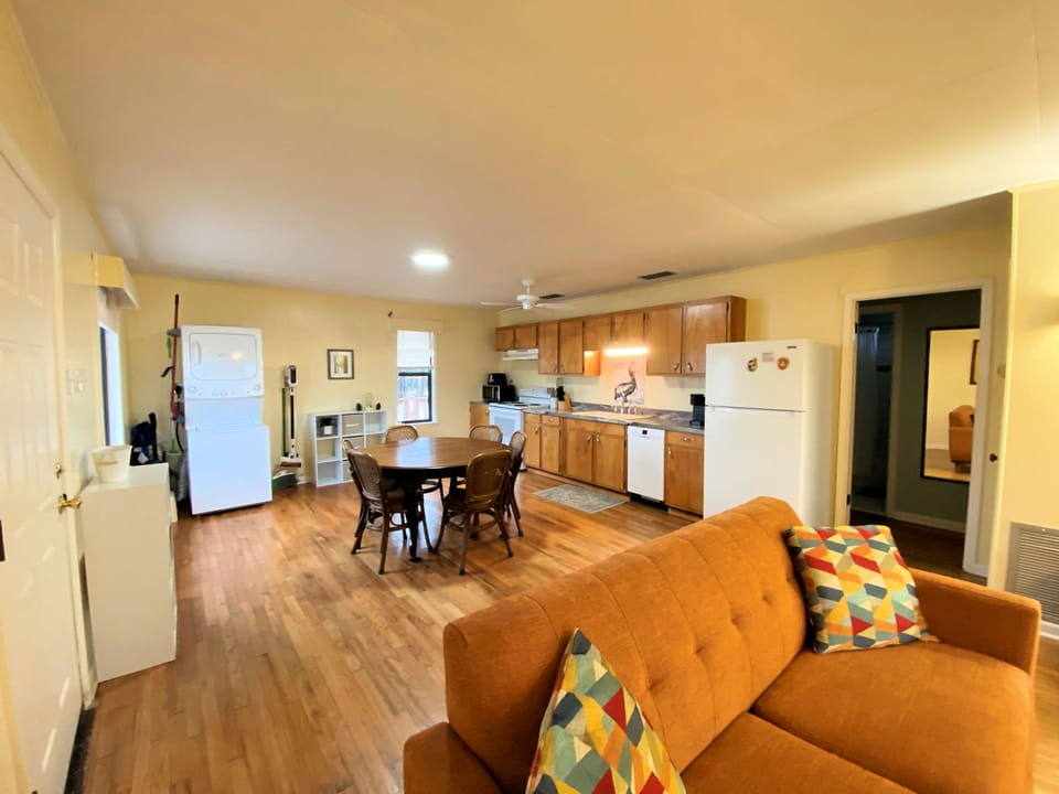 Your spacious open-plan living area blends comfort with convenience, featuring warm wood floors and a fully equipped kitchen for home-cooked meals.