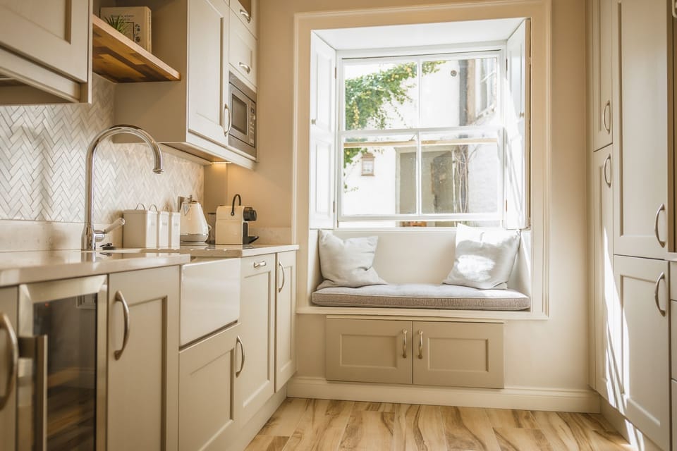 Bright, modern kitchen appliances and window seat in Porte House.