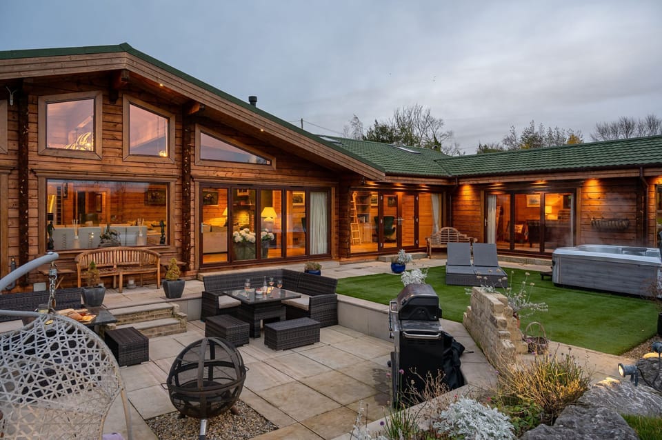 Exterior of Valley View lodge with patio seating area and hot tub.