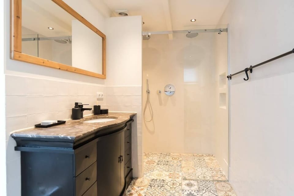 Elegant and spacious, featuring a luxurious walk-in rain shower and warm lighting for a spa-like experience.

