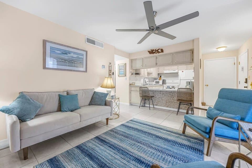 Cozy living area with blue accents and an open kitchen layout.