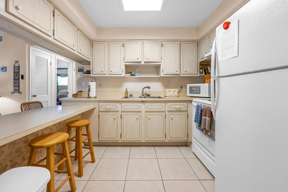 Functional kitchen with ample cabinetry and a breakfast bar with wooden stools