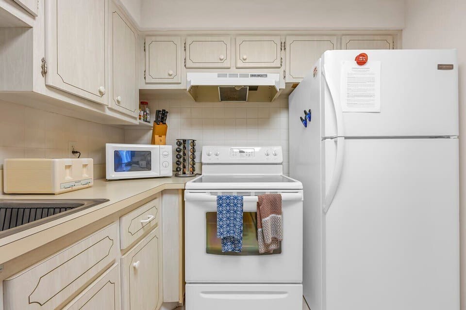 Compact kitchen with white appliances and ample cabinet storage