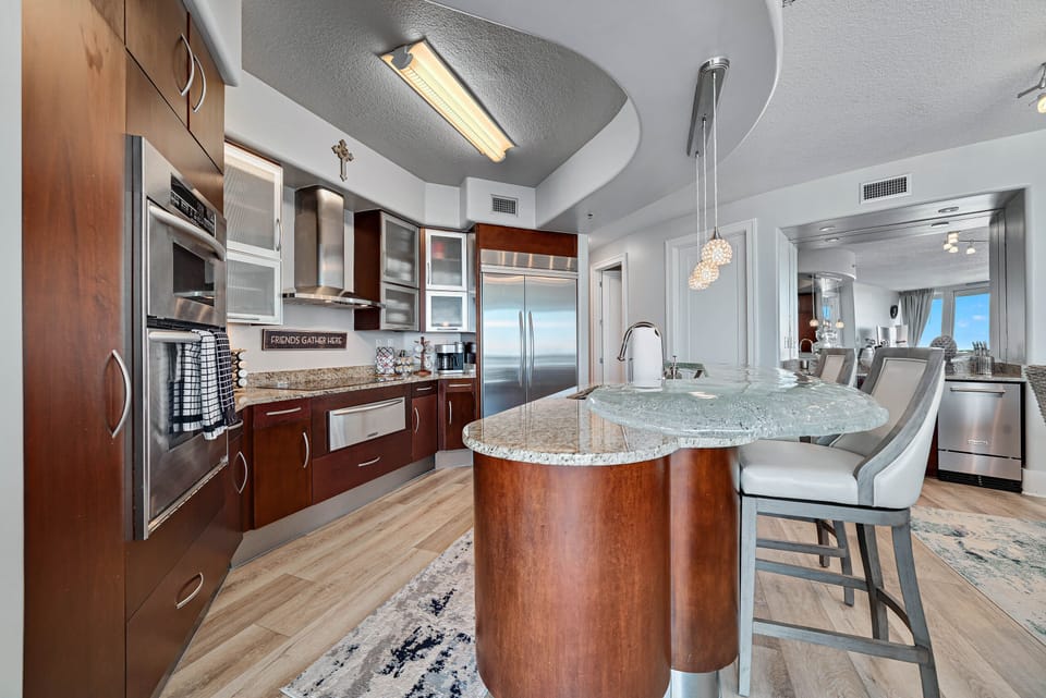 Exquisite details abound in this high-end kitchen, from the frosted glass cabinetry to the professional-grade appliances. Experience luxury in every culinary creation.