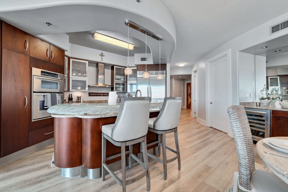 The modern kitchen island with bar seating offers a casual dining option, while the open layout maximizes natural light and showcases the stylish finishes throughout.