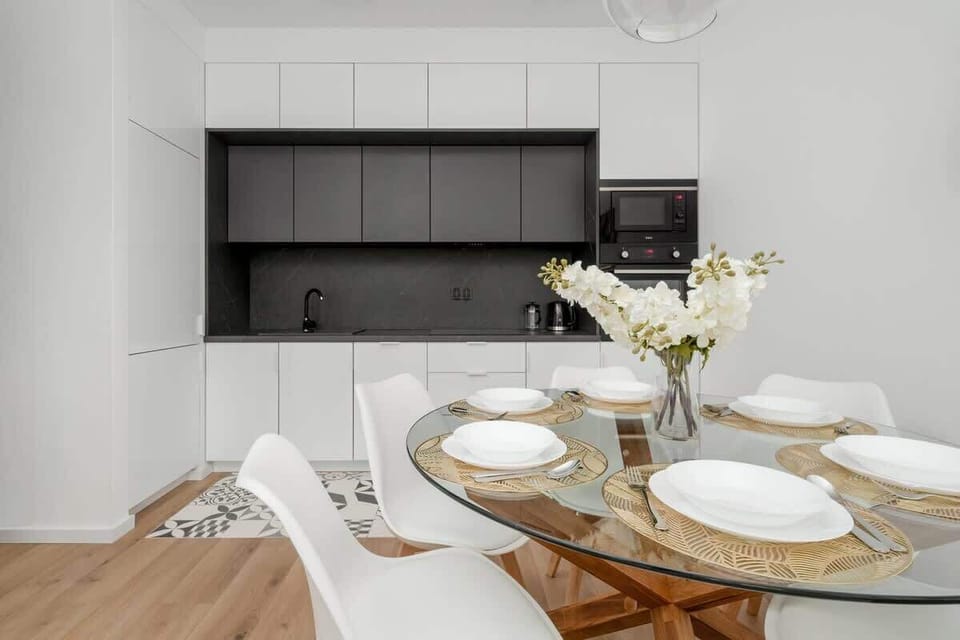 A dining area with a set table and open kitchen in the background. Designed for both function and style.