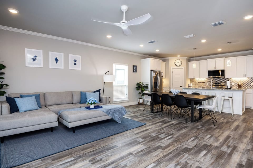 Relax in your modern open-plan living space featuring cozy seating, fully equipped kitchen, and stylish dining area perfect for memorable meals.