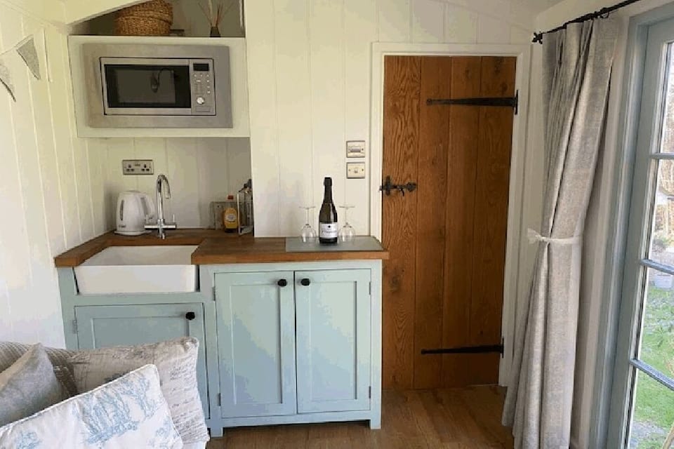 Hut mini kitchen with under counter fridge.  