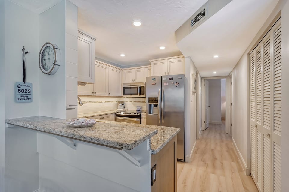 Modern, fully equipped kitchen with granite counters and all stainless appliances