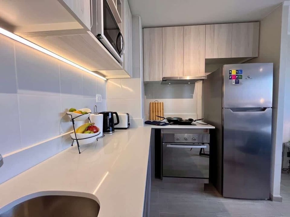 Contemporary kitchen w/ sleek counters & integrated appliances