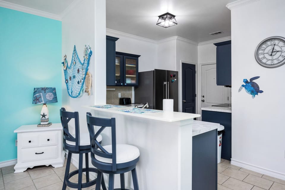 Your coastal-inspired kitchen invites you to prepare meals while enjoying the soothing turquoise accents and nautical touches.