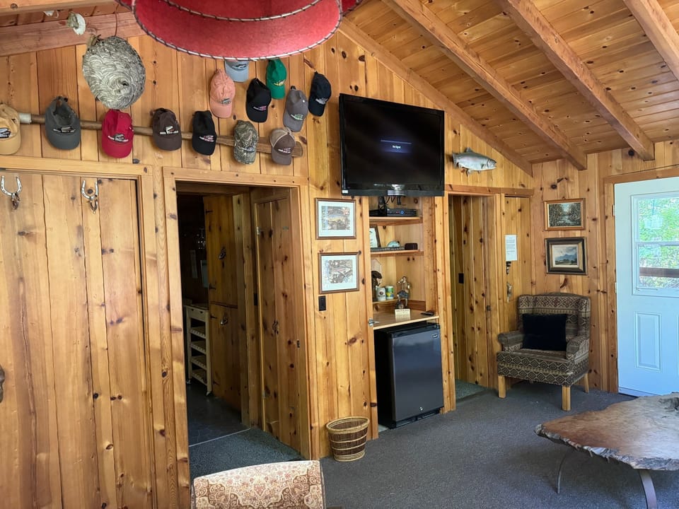 Front porch living room with TV, mini fridge, full size futon, card game table