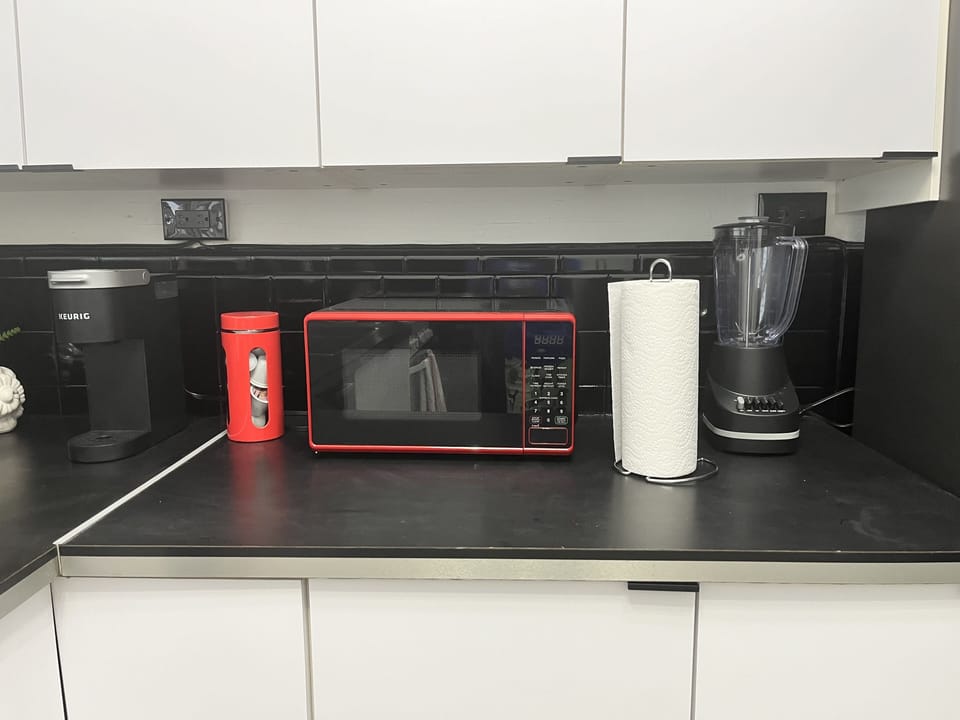 Microwave, blender, coffee pods, and tea.