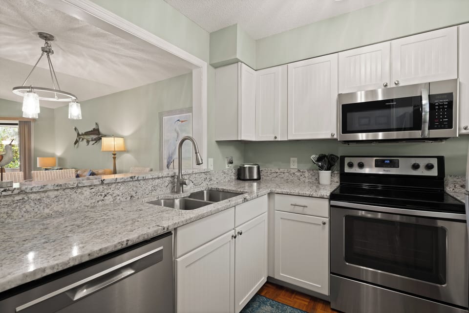 The kitchen has a window that overlooks the dining table and great room.