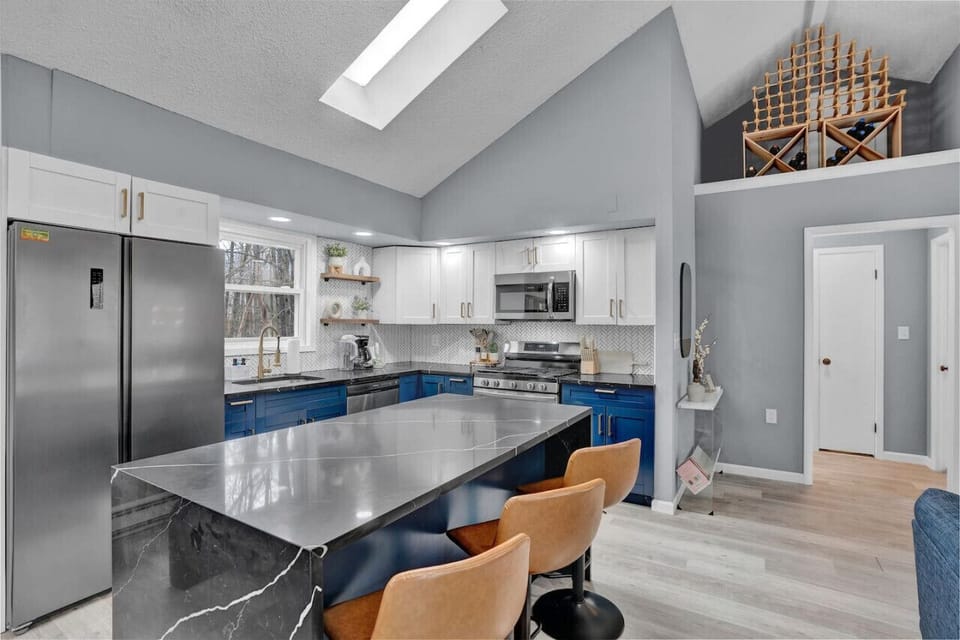 Elevate your gatherings in our high-ceiling living area, adorned with leather adjustable bar stools perfect for meals or engaging conversations. Experience the epitome of style and comfort in every moment of your stay.