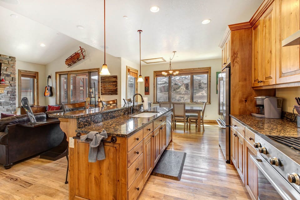 Step into your open-concept kitchen with granite counters, warm wood cabinets, and stunning mountain views from every window—perfect for cooking together and soaking in the scenery.