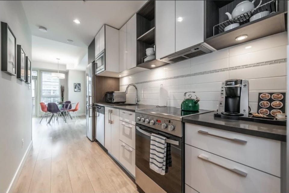 Fully equipped kitchen galley complete with full-sized stainless steel appliances, electric range, and built-in microwave.