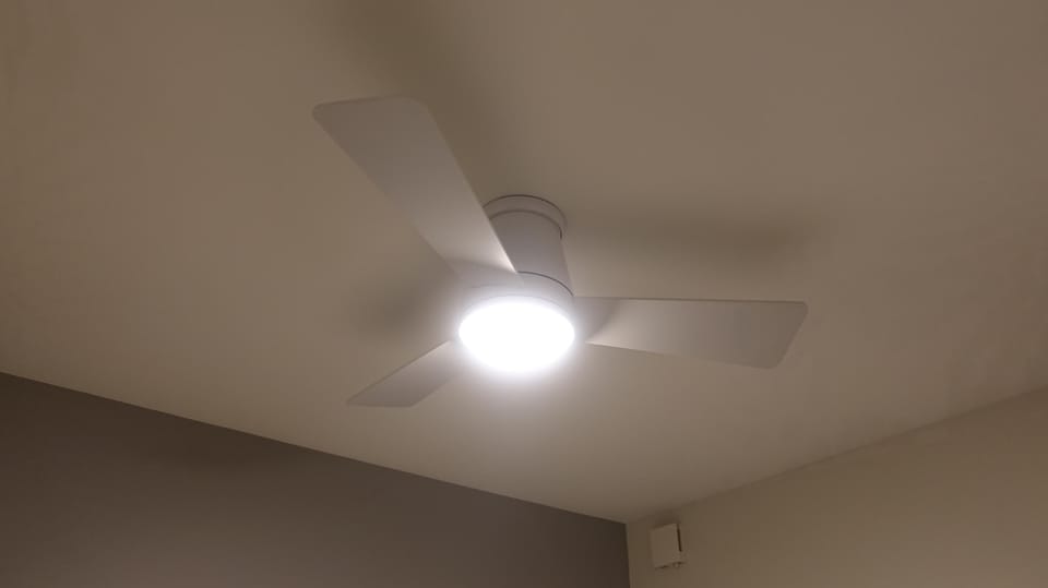 Close-up detail of the overhead ceiling fan fixture in the primary bedroom suite.