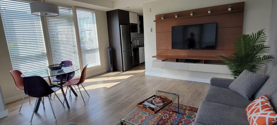 Broad view connecting the dining nook, open living space, and built-in media center.