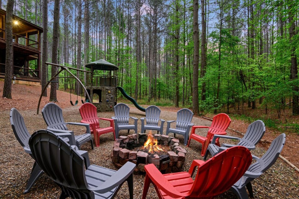 Outdoor fire pit seating area with comfortable Adirondack chairs and forest views