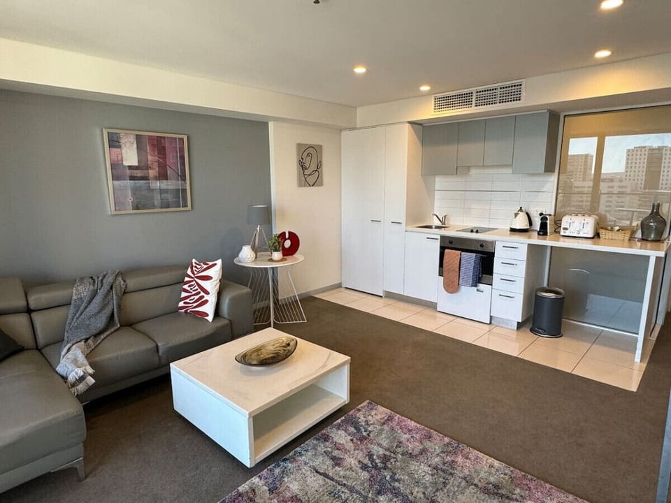 Comfortable sofa, coffee table, and TV area with a view over the city.