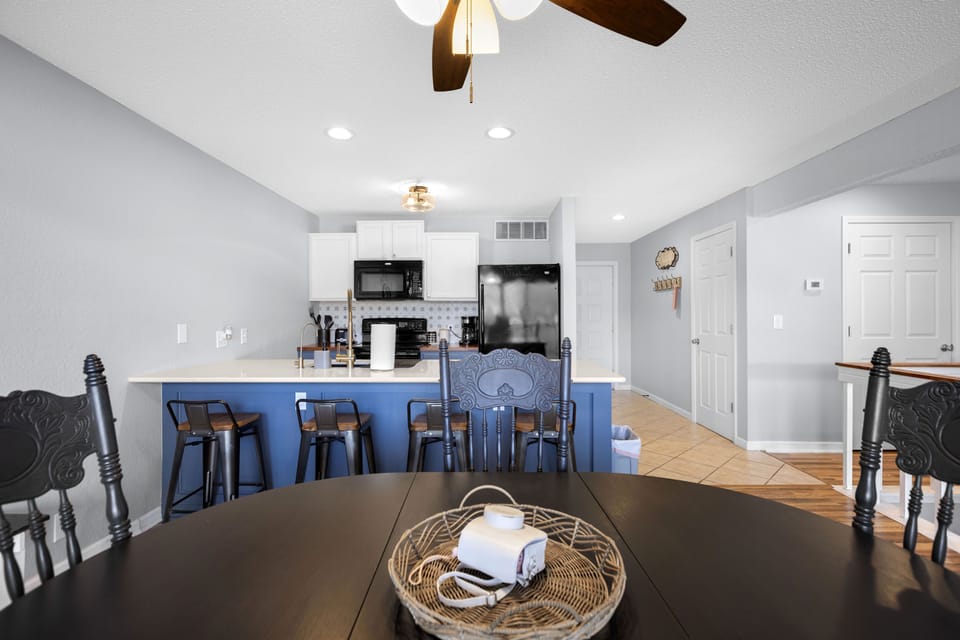 Modern kitchen with eat in bar and oven, dishwasher, microwave and refrigerator.