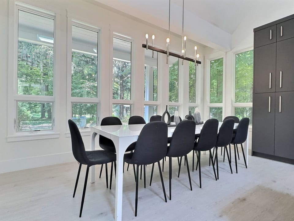 Sunlit dining area with expansive windows—serene and elegant for every meal.