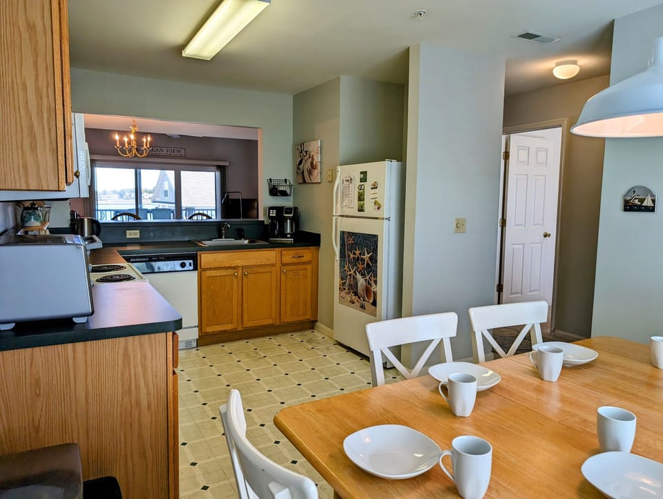 605 Crowley Drive - Fully Equipped Kitchen - The kitchen is designed for functionality with warm wood cabinetry, modern black countertops, and white appliances. A secondary dining nook or prep area provides additional versatility for meal times.