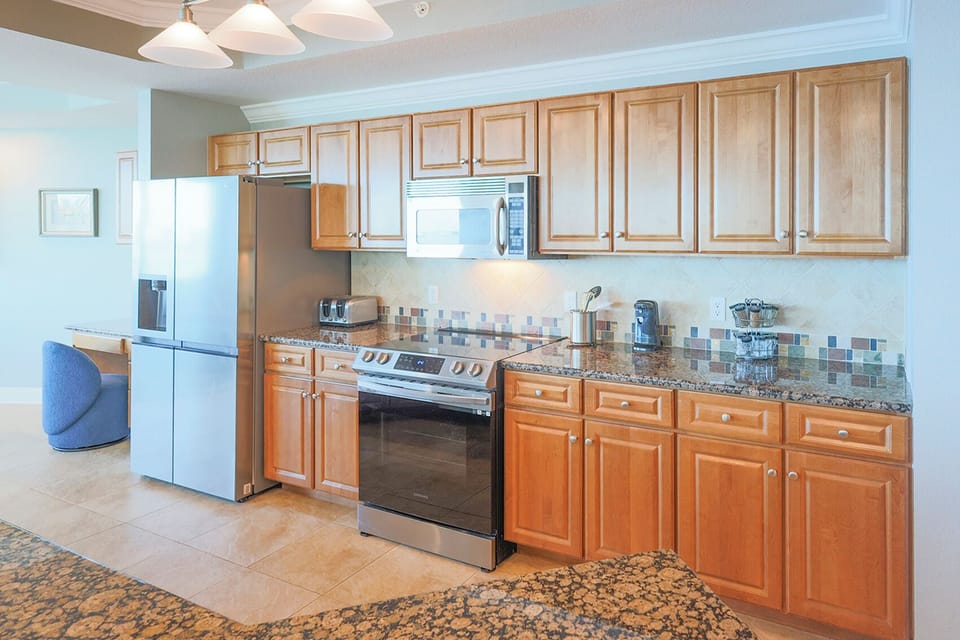 The kitchen features stainless appliances, wooden cabinets, and granite countertops which is perfect for family gatherings