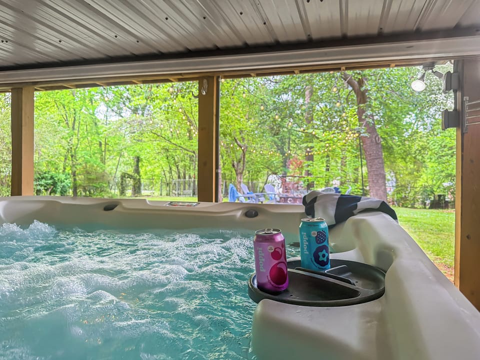 Sink into the hot tub with the trees closing in around you — a cold drink on the rail, the day washing off, and downtown a short walk away when you're ready.