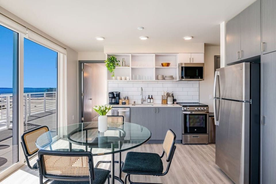 A fully equipped kitchen flows right into the dining area, with the skyline as your backdrop.