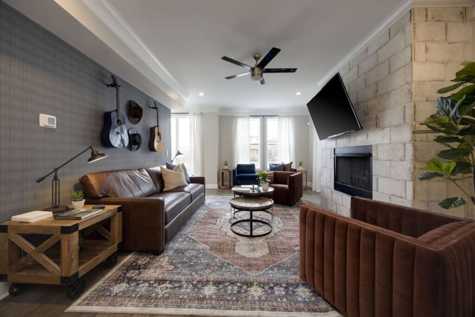 Cozy living room with a stone fireplace and warm leather seating.