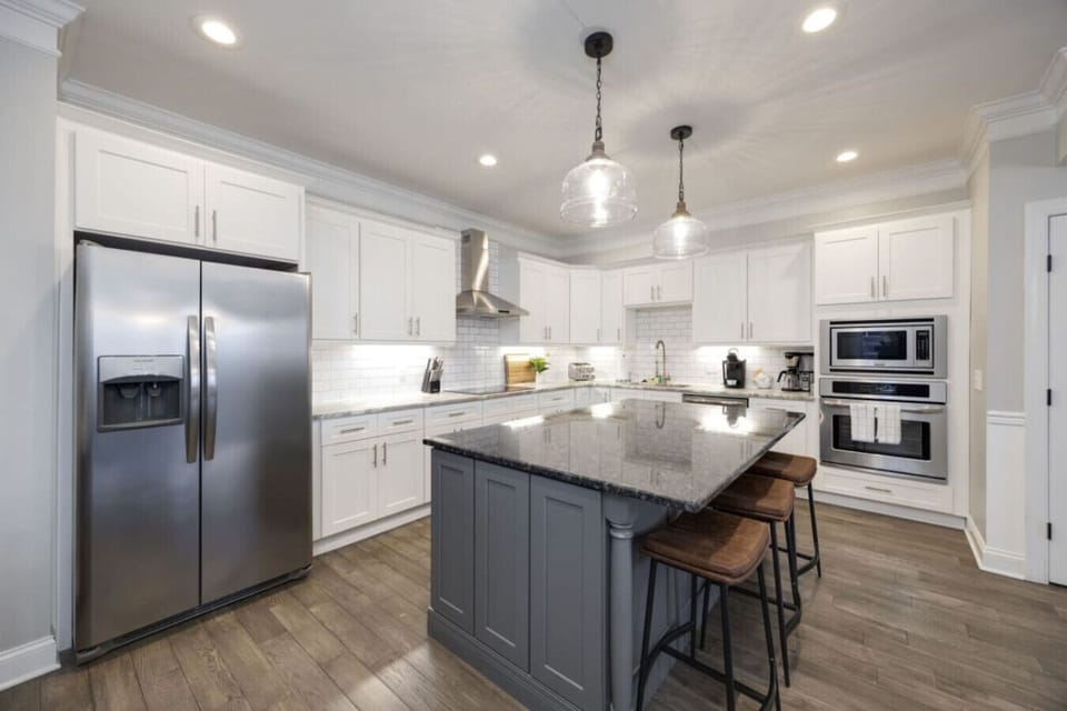 Sleek white kitchen with a center island and premium appliances.