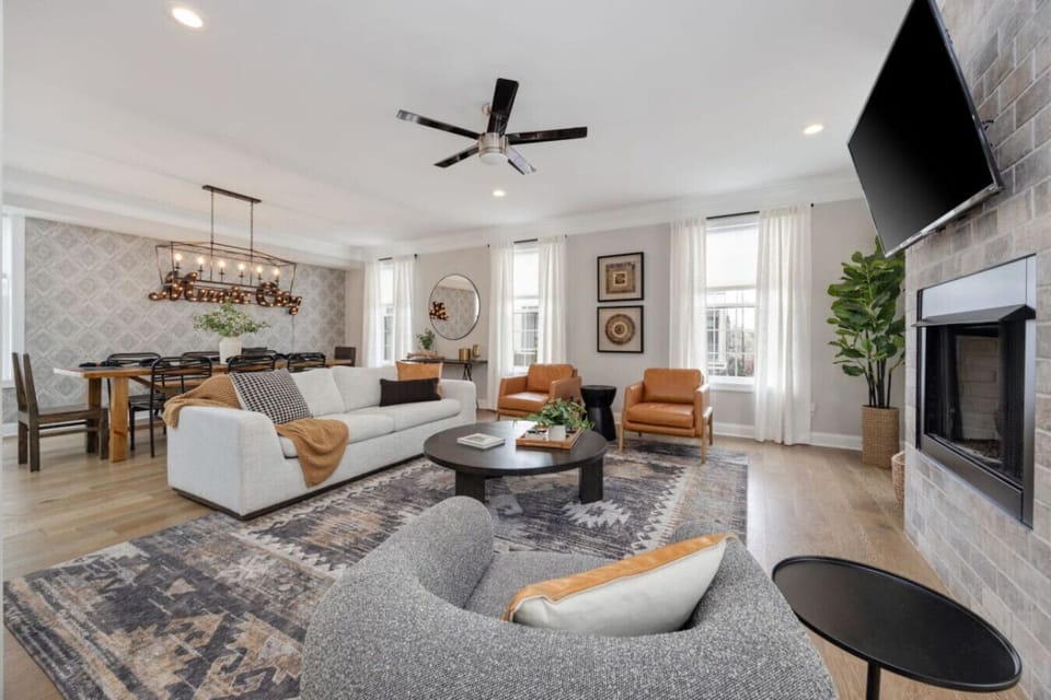 Chic living room with a stone fireplace, designer wallpaper, and plush seating.