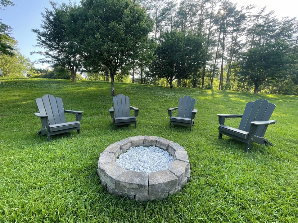 Outdoor fire pit with Adirondack chairs.
