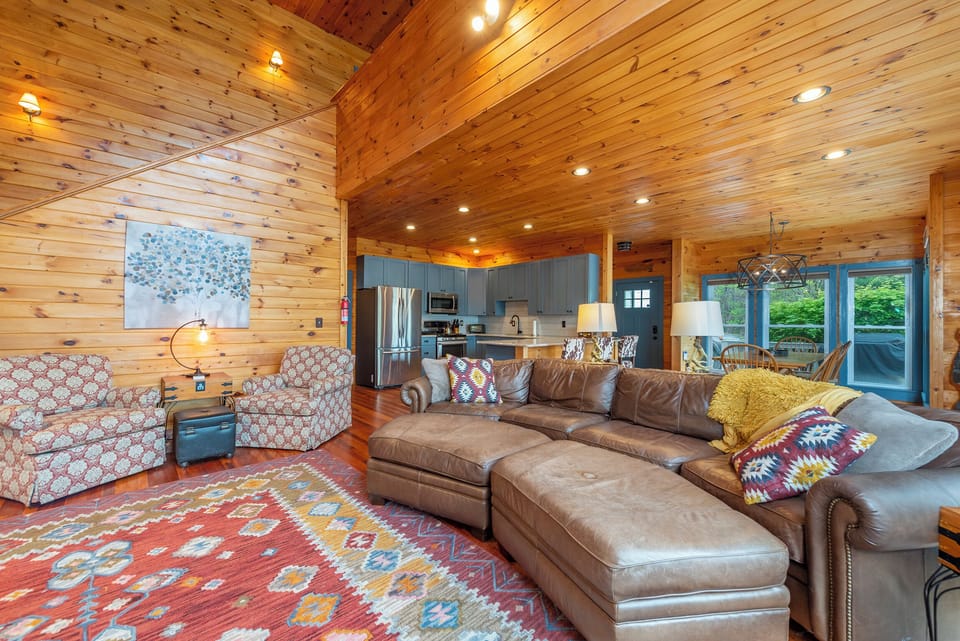 Open-concept main floor with SmartTV for streaming, gas log fireplace, and access to the deck overlooking the mountains and lake