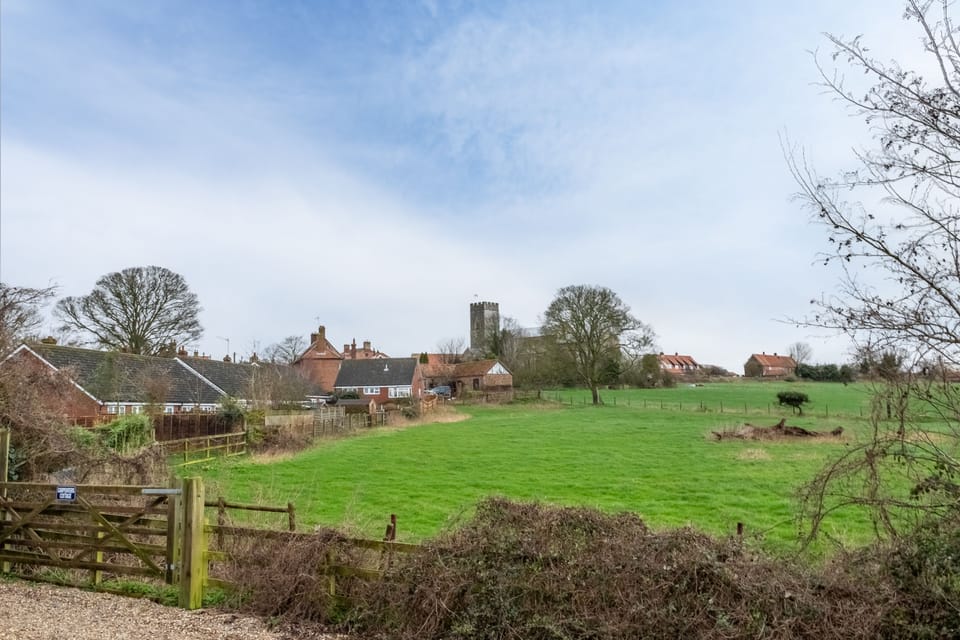 The paddocks at the rear of the cottage, with a view of the distant church
