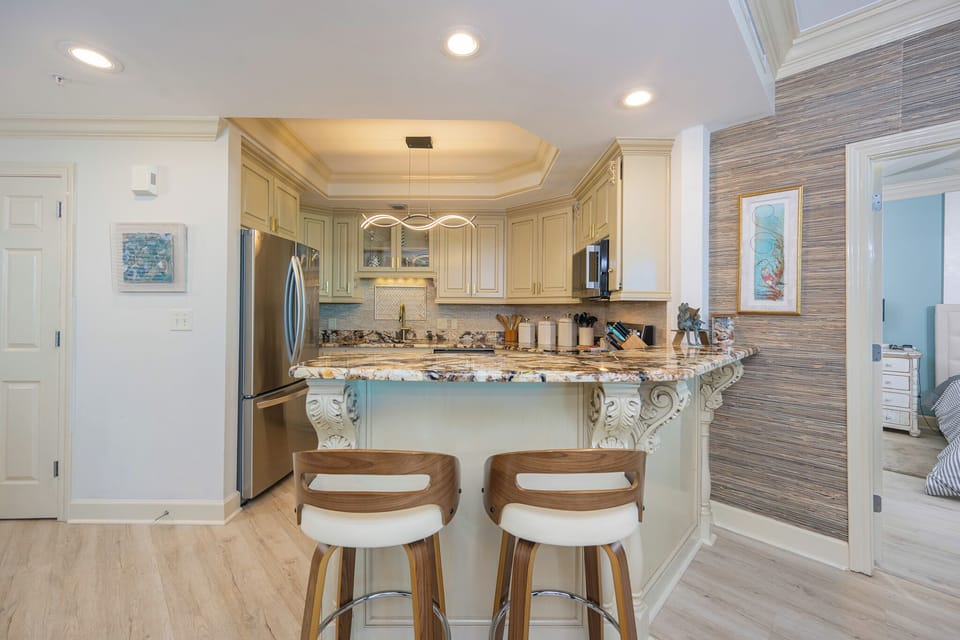 Prepare meals in this kitchen with elegant cabinetry, stainless appliances, and stylish countertops