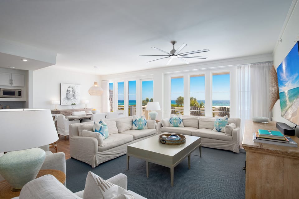 Your bright, coastal living space flows seamlessly from kitchen to lounge, where ocean breezes drift through panoramic windows.