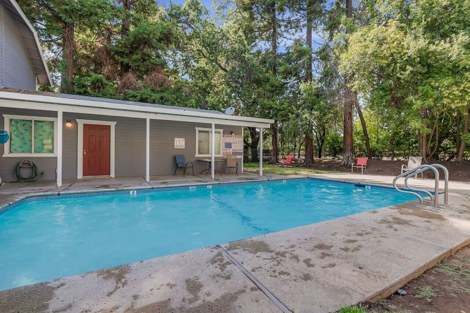 Relax by the spacious outdoor pool surrounded by peaceful greenery