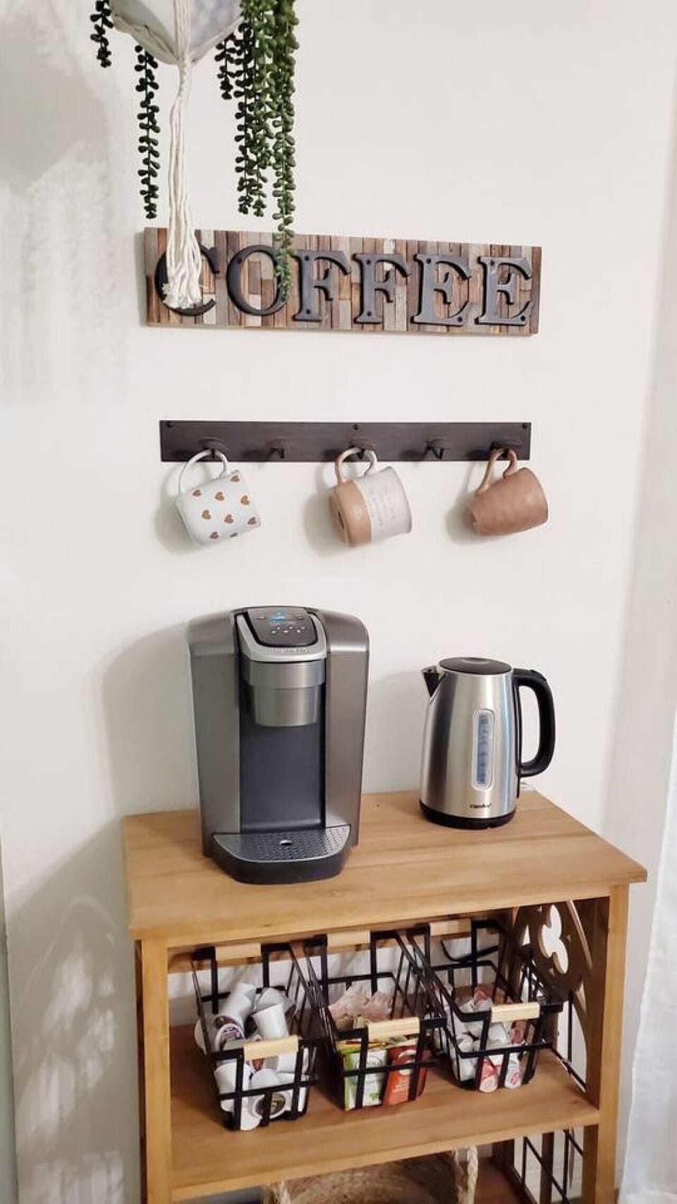 Charming coffee station with Keurig, kettle, mugs, and a variety of teas and coffee pods.