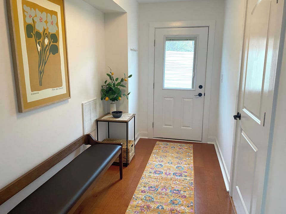 entry hall with bench, full bathroom on right